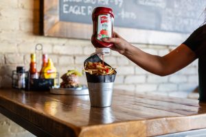 French's Ketchup squeezed onto fries at Smoque N Bones, Toronto