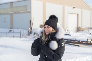 Ice fisherwoman taking pictures in Moose Knuckles at Lake Winnipeg